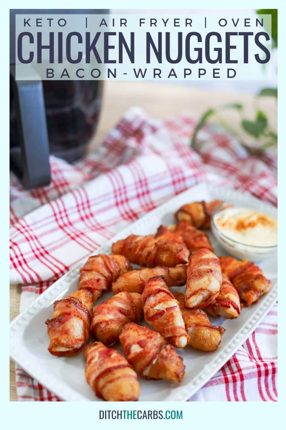 bacon wrapped chicken nuggets on a white plate with a red cloth and an air fryer
