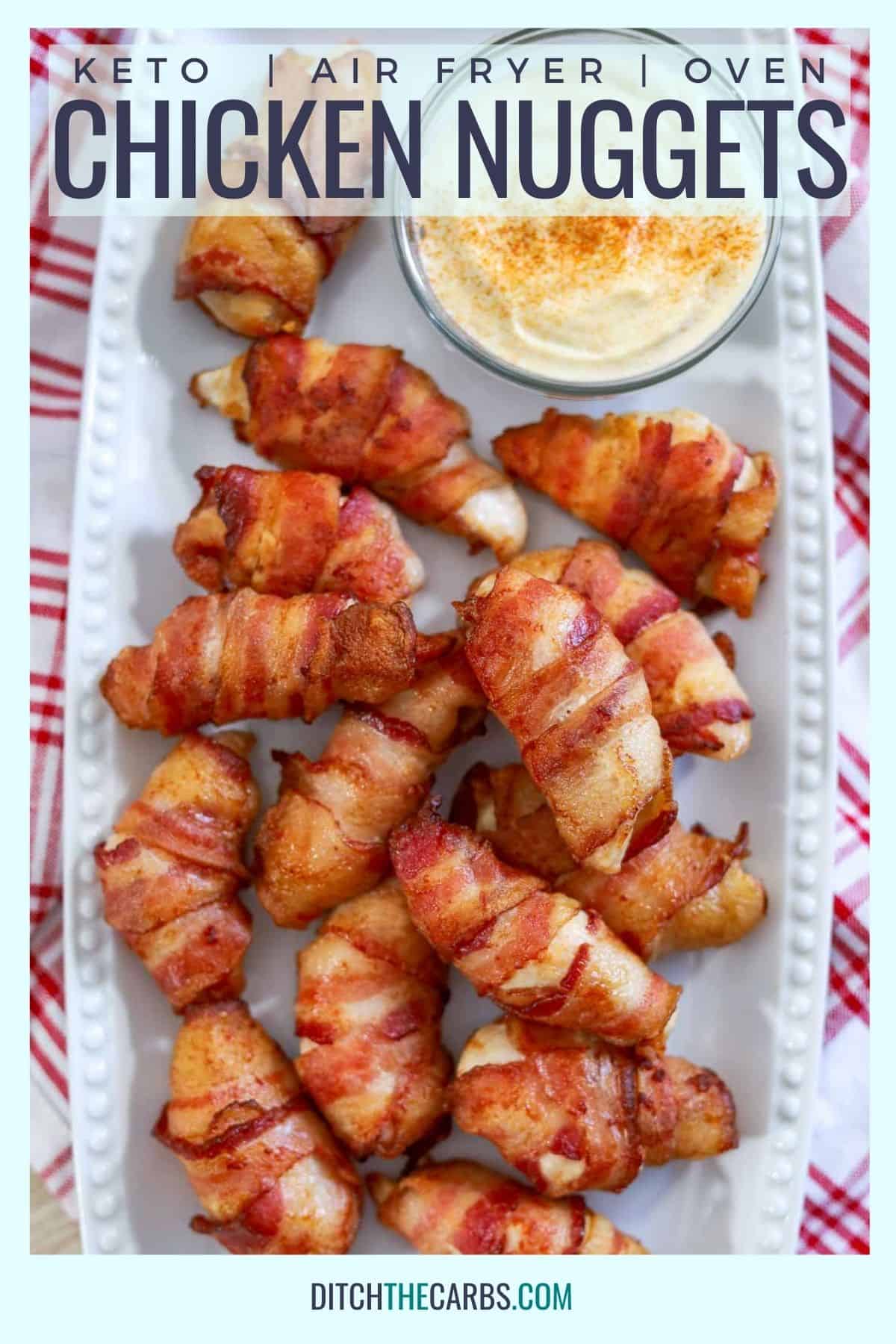 bacon wrapped chicken nuggets on a white plate with a red cloth and sauce