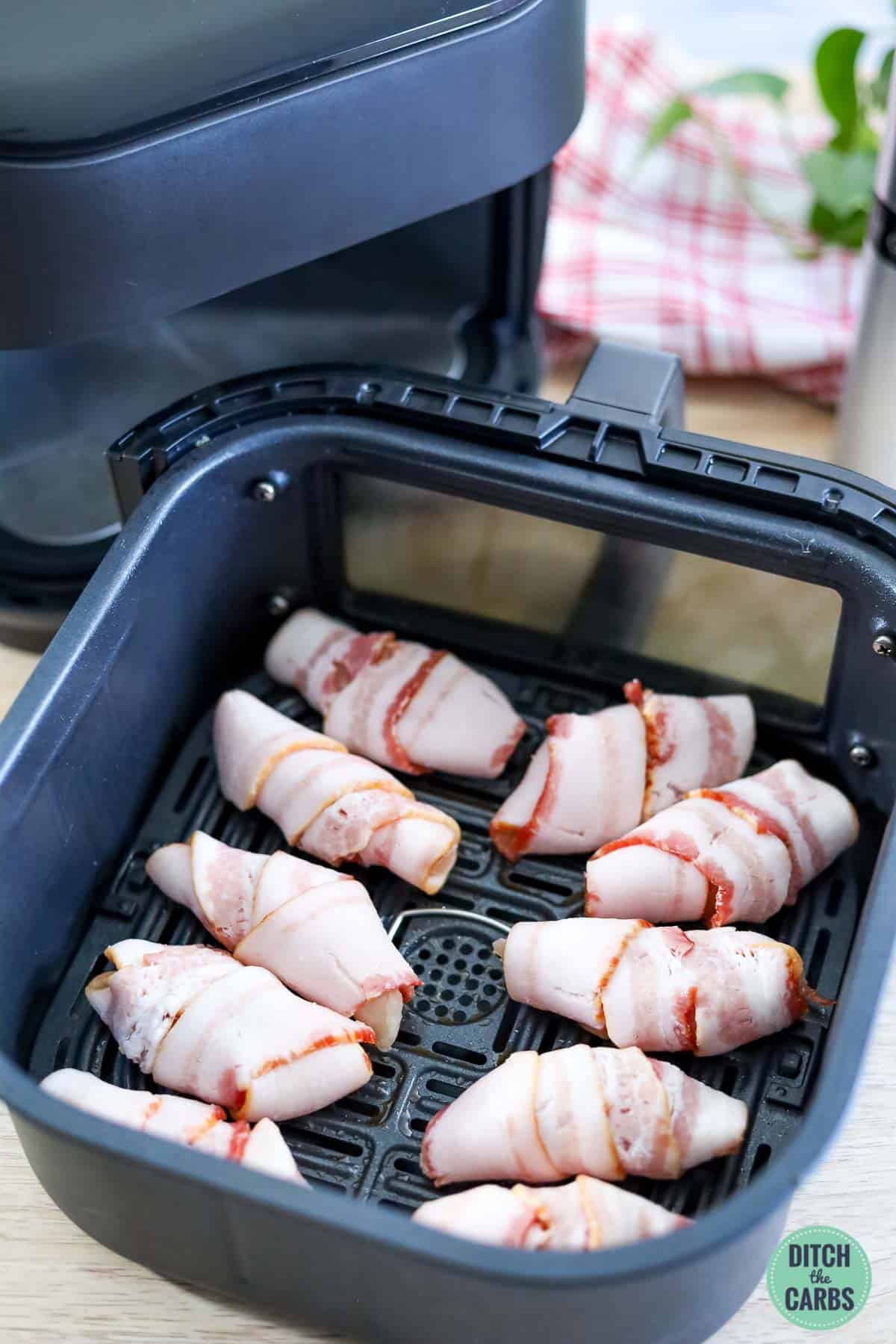 bacon wrapped chicken nuggets in an air fryer basket