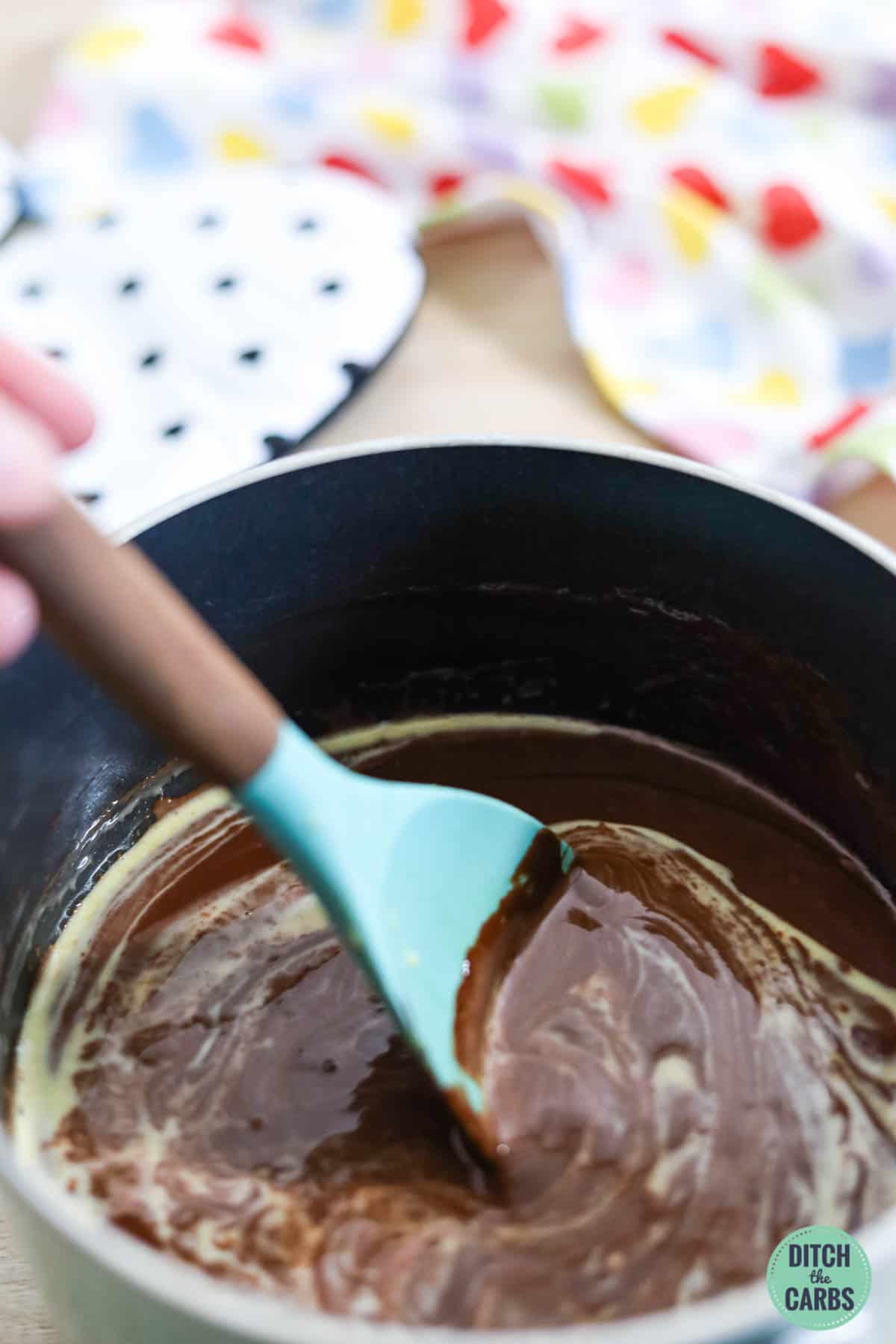 mixing sugar-free chocolate with eggs in a saucepan