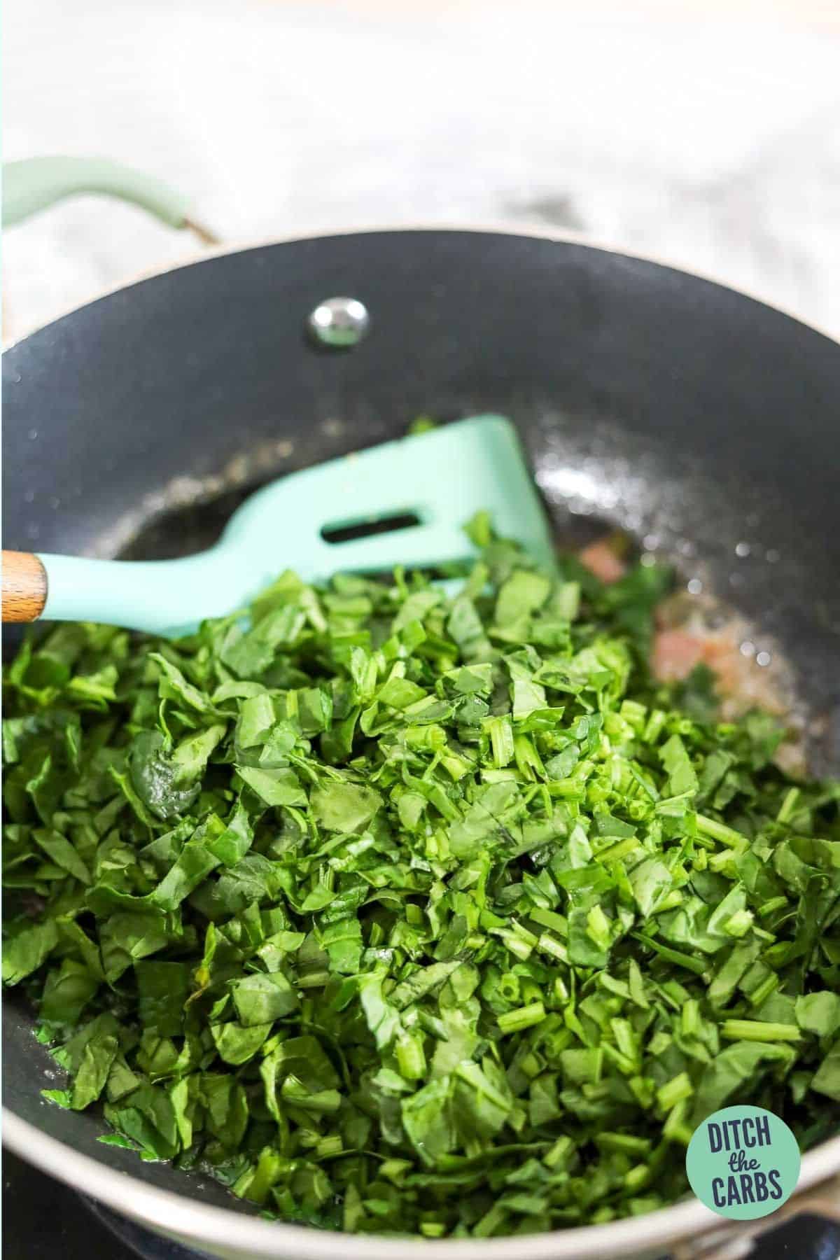 chopped spinach frying in a pan