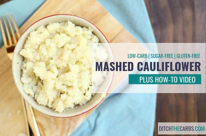 low-carb thanksgiving mashed cauliflower in a red bowl on a wooden board