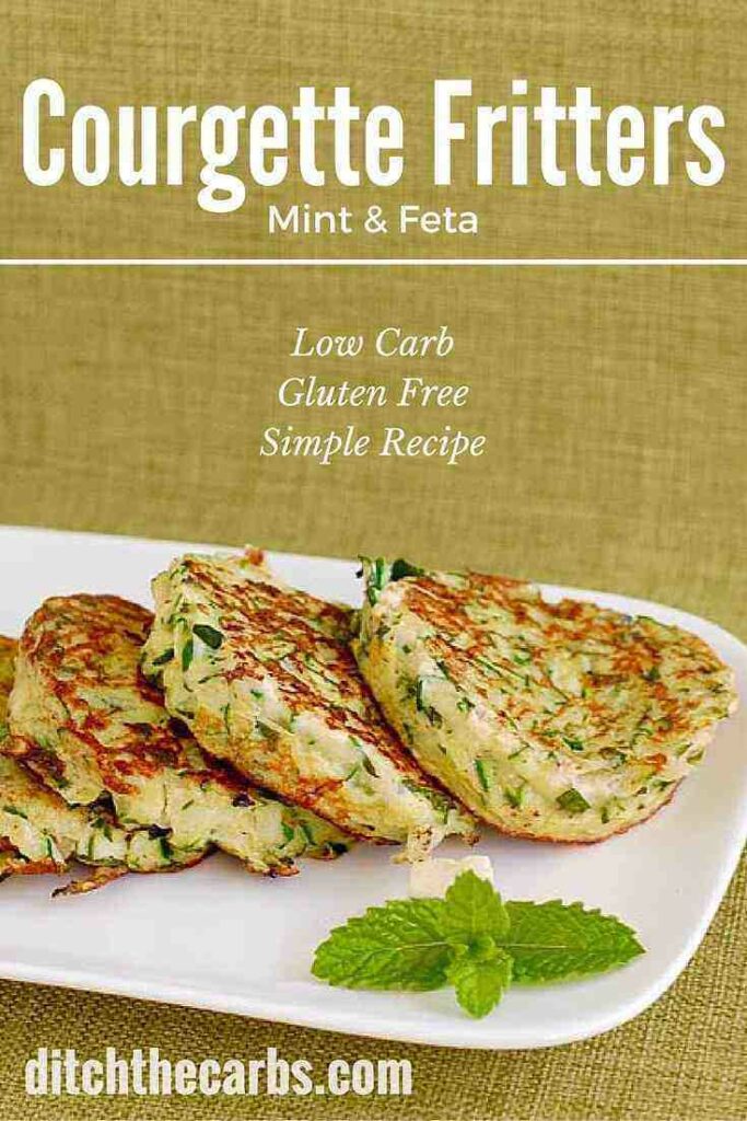 courgette mint feta fritters on a white rectangle platter and green cloth background