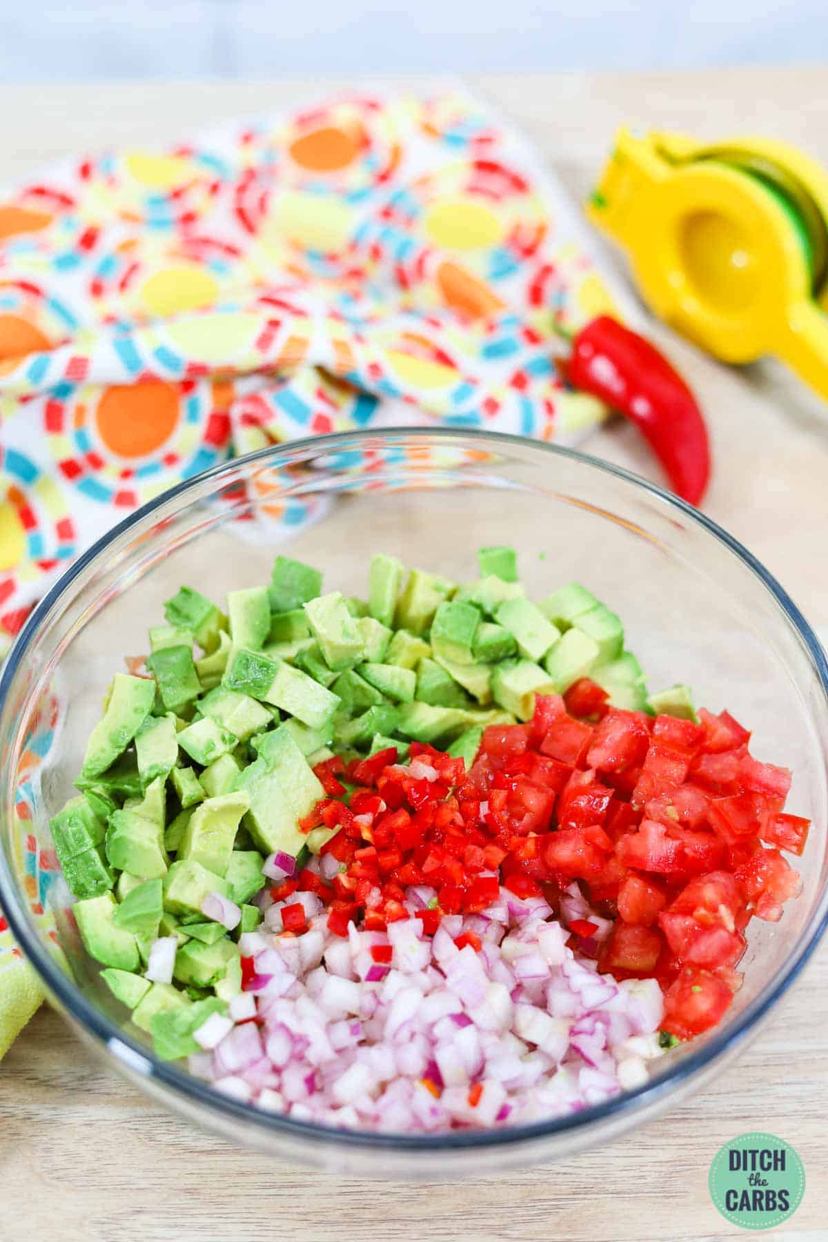 a bowl of chopped avocados, tomatoes, and onions