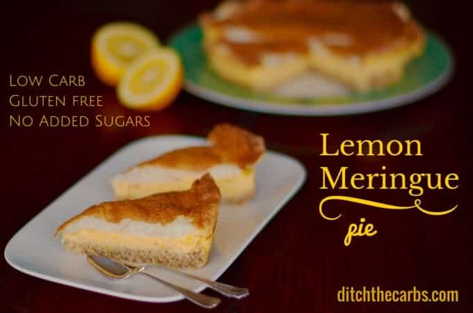 Low-carb lemon meringue pie sliced and served with antique cutlery and fresh lemons