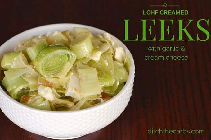 Amazing low carb creamed leeks with garlic and cream cheese on a dark dining table 