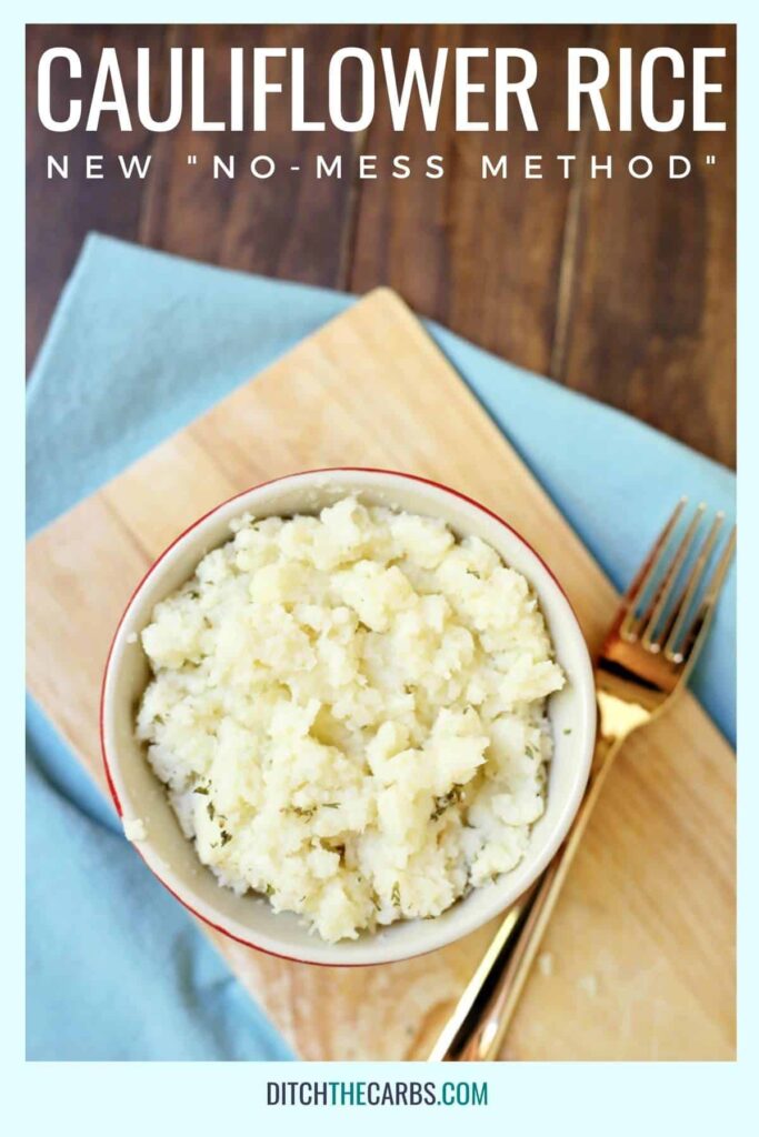 A close up of cauliflower rice on a bread board with a gold fork