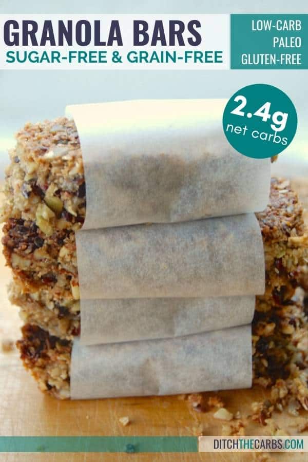 grain-free granola bars wrapped in baking paper stacked on a wooden chopping board