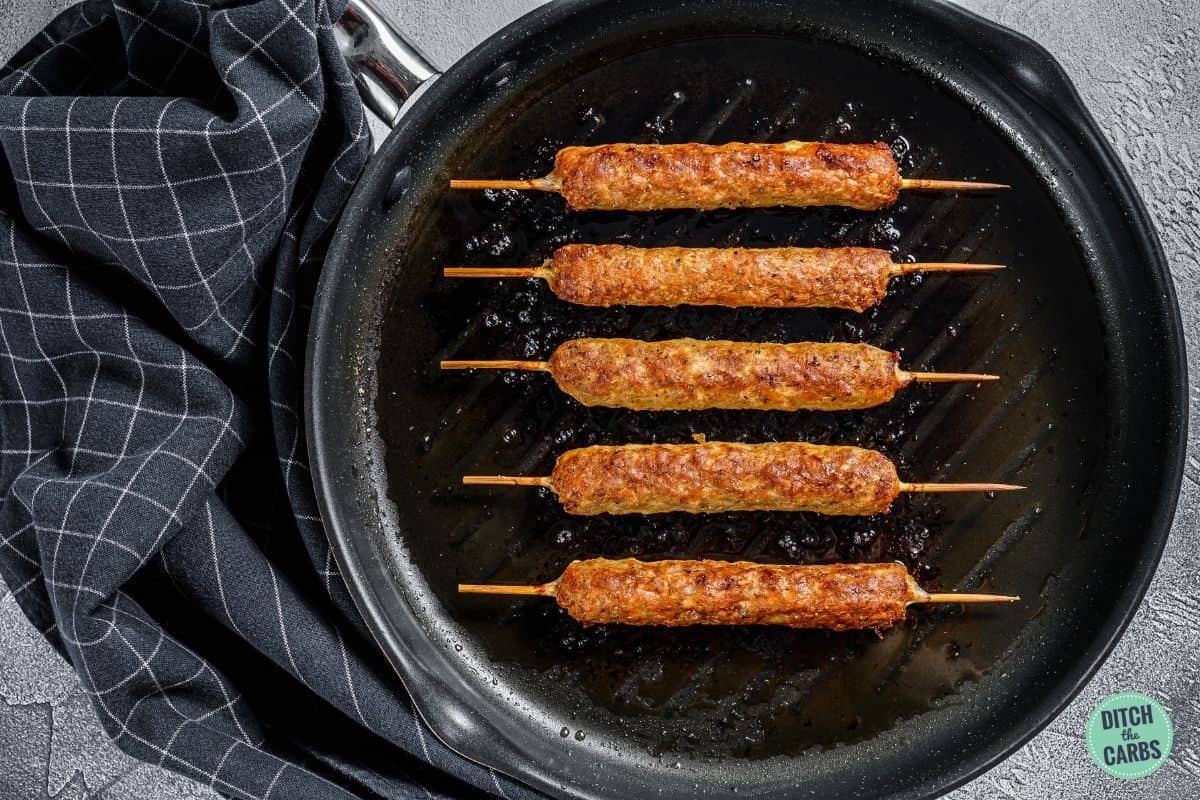 keto lamb kebabs cooking in a frying pan