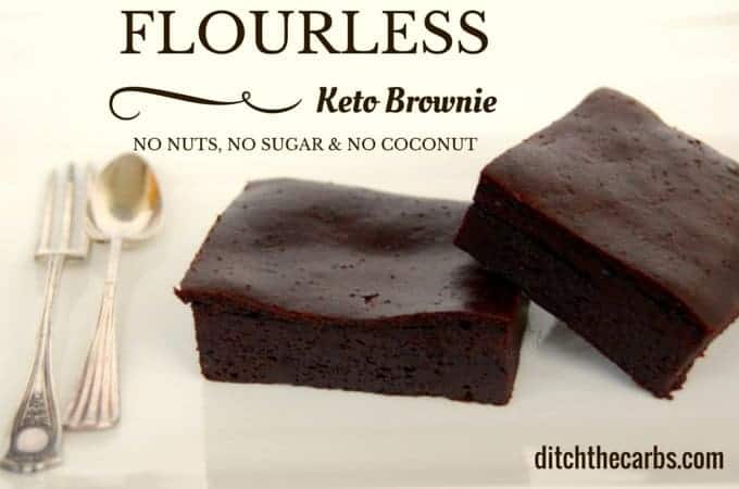 Flourless keto brownie sliced on a white plate with silver cutlery