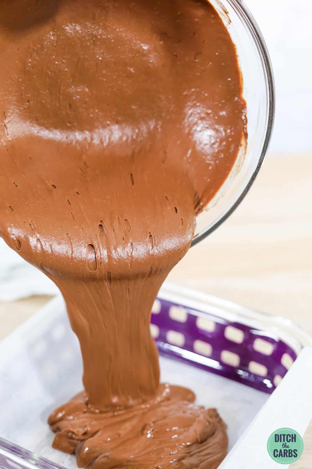 pouring brownie batter into a pan