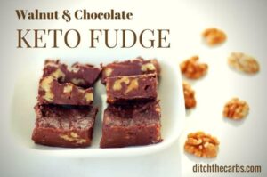 Chocolate walnut keto fudge sliced into squares and placed on a white china plate with walnuts on the table