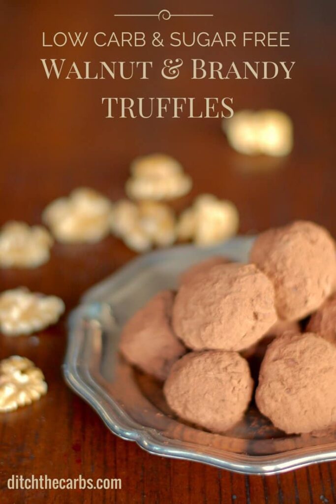 brandy truffles sitting on a silver dish on a dark wooden table