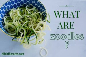 A bowl of zucchini noodles spilling onto the kitchen bench