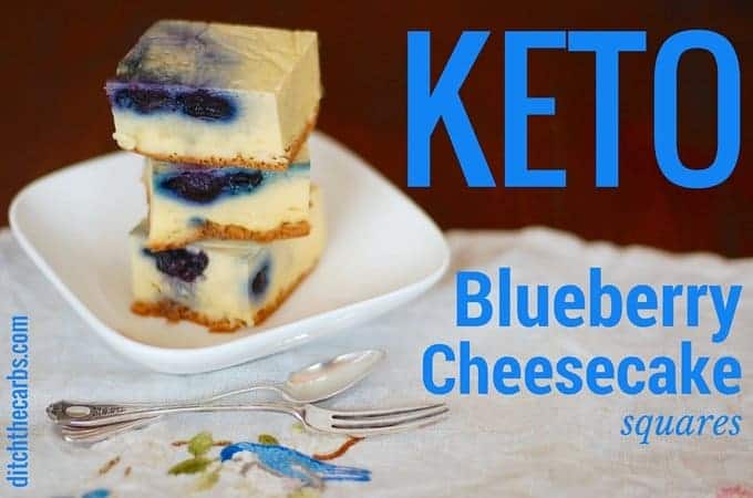 Keto blueberry cheesecake squares sitting on a white plate with antique cutlery