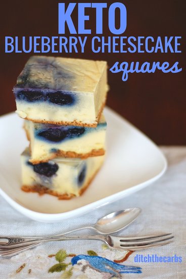 Keto blueberry cheesecake sliced into squares and stacked on a plate