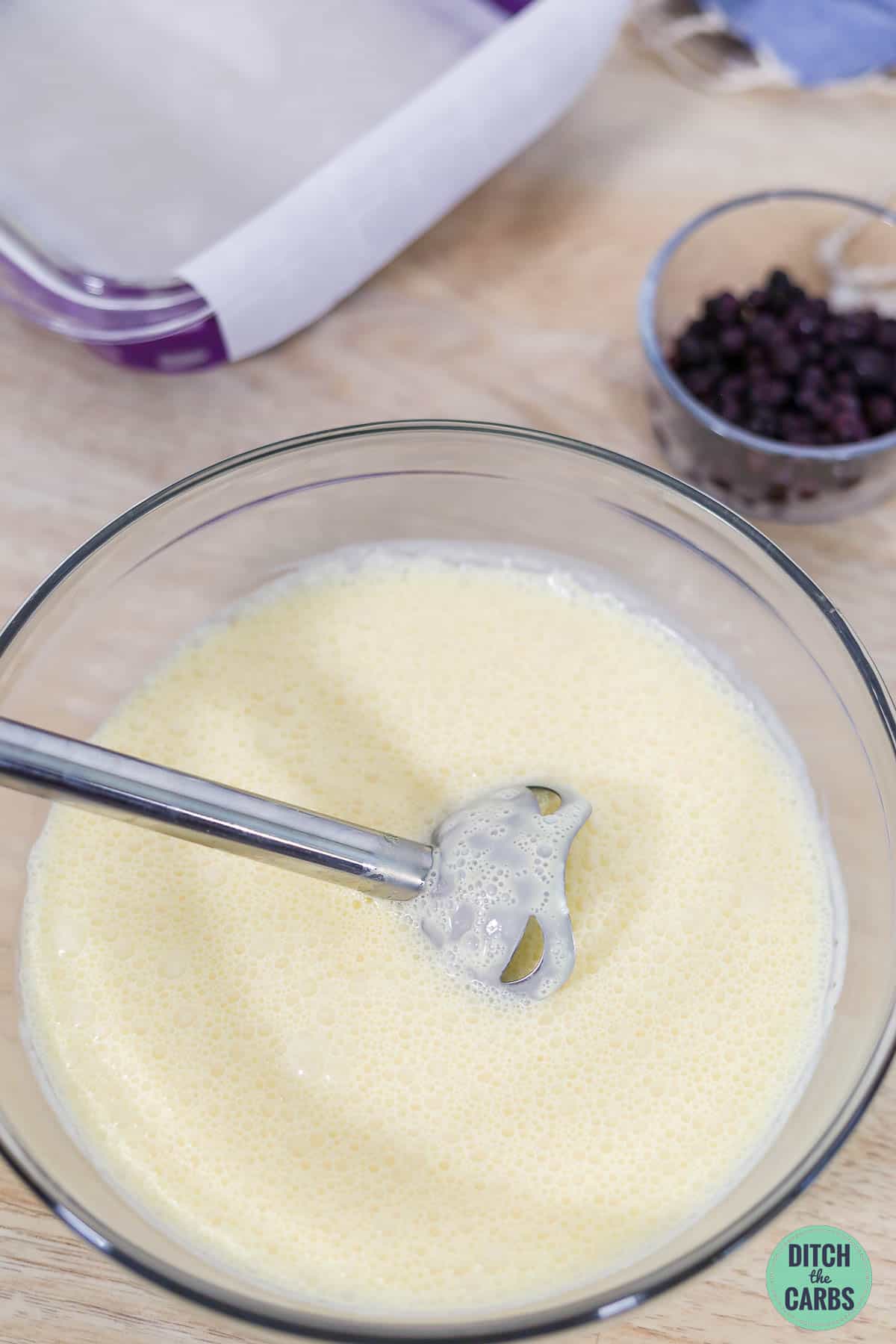 a stick blender in mixing bowl with sugar-free cheesecake filling
