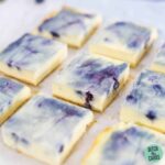 vanilla berry keto cheesecake bars lined up on a white platter