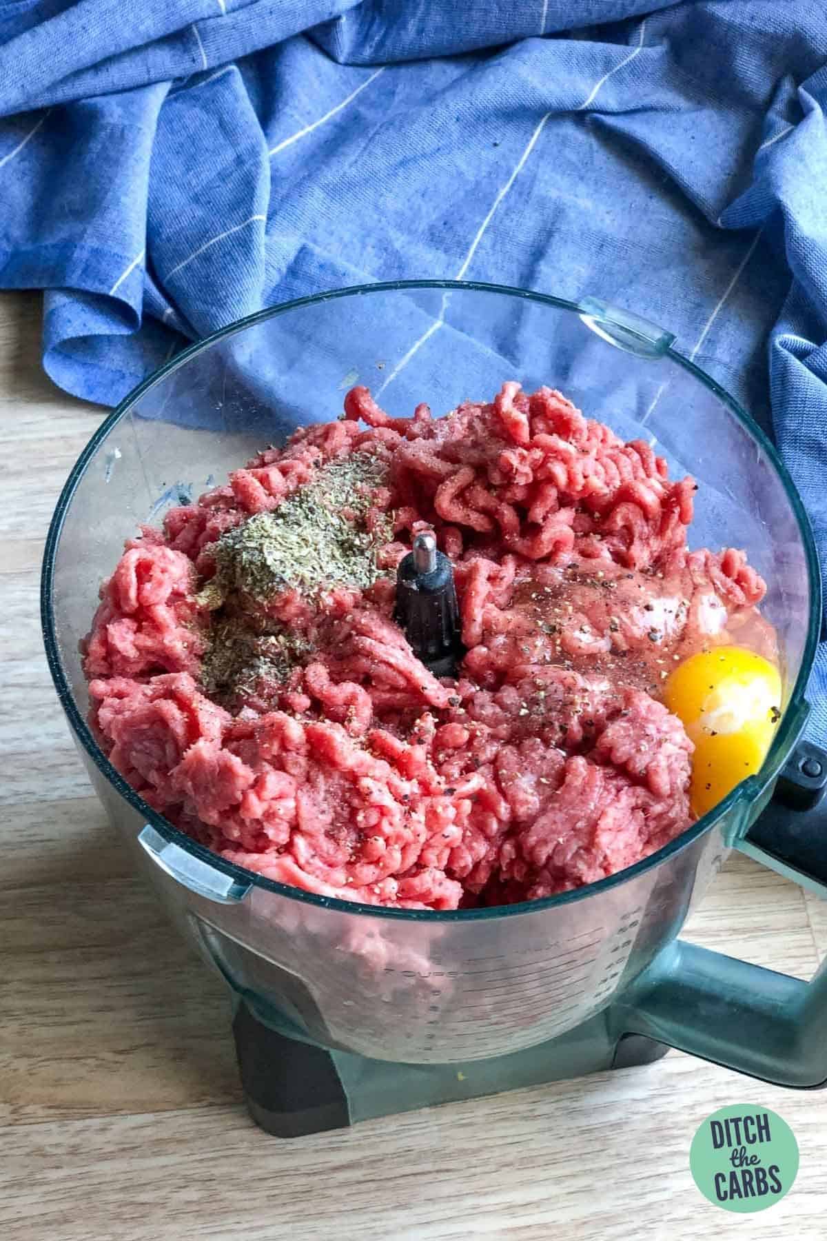ground beef and ingredients to make keto meatballs in a food processor