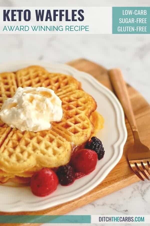 To keto waffles sitting on a plate with whipped cream and berries