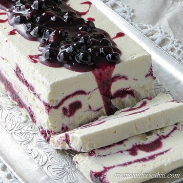 Coconut cream semi freddo served on a silver tray with fresh berry sauce