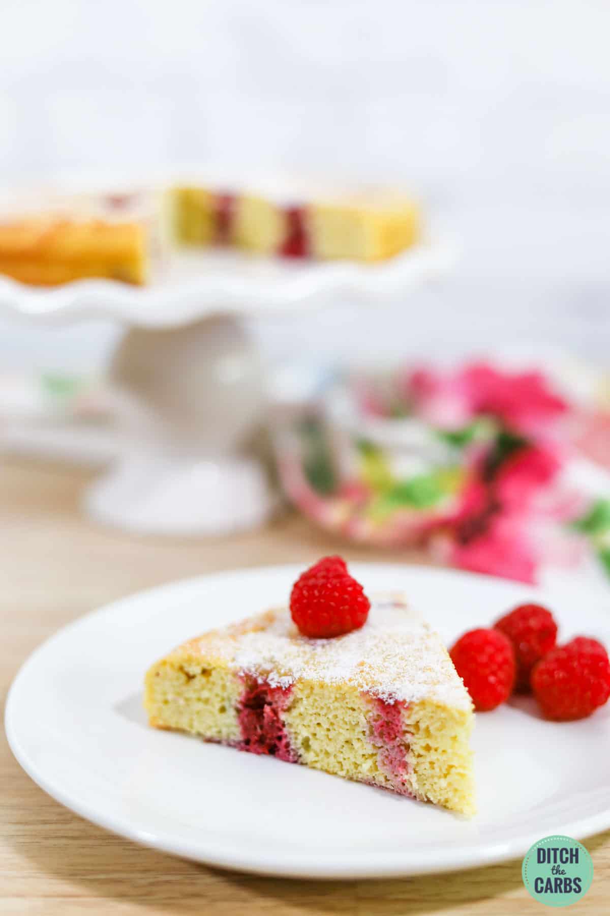 sliced berry keto sponge cake on a white cake stand