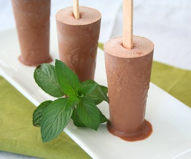 Frozen chocolate mint popsicles with fresh mint leaves