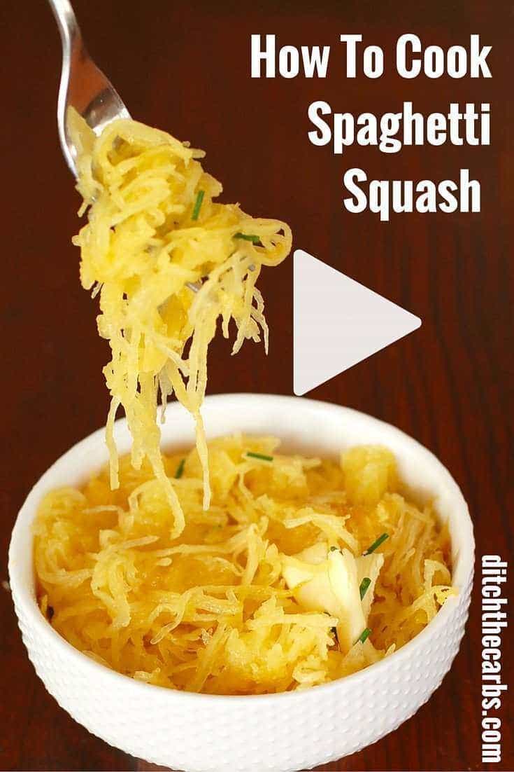 Spaghetti squash being lifted from the serving bowl with a fork