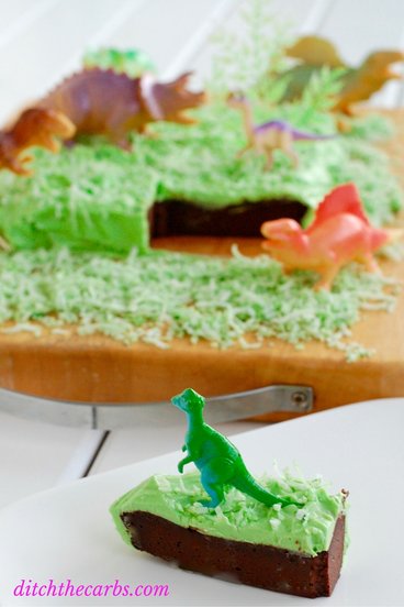 Child's birthday cake with green frosting and dinosaurs