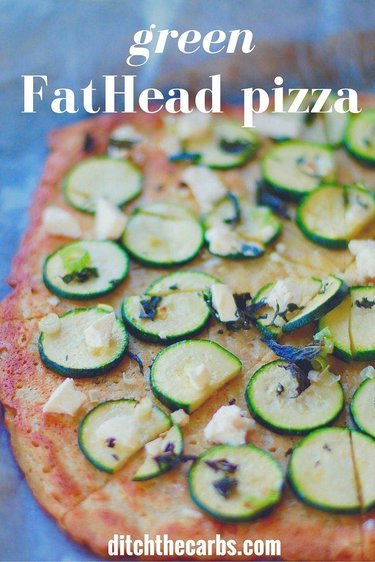 Green FatHead Pizza cut and sliced on baking paper for the top 30 low-carb vegetarian recipes