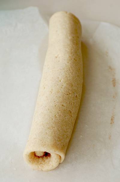 rolled out Chelsea bun bread dough on baking parchment about to be cut into slices