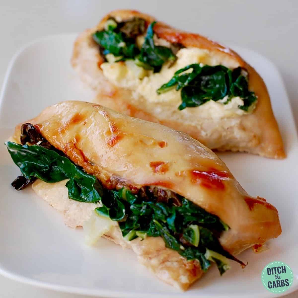 spinach stuffed chicken served on a white square plate