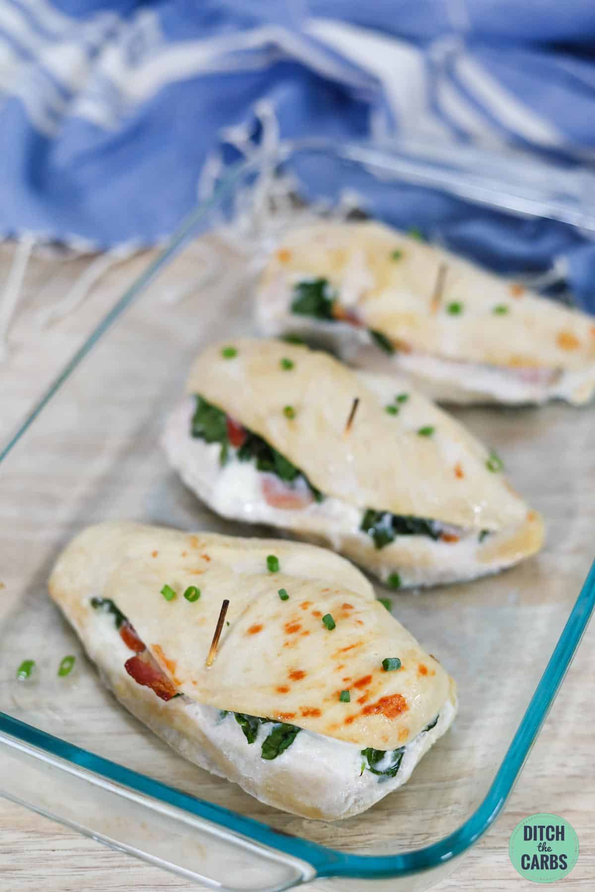 3 baked chicken breasts stuffed with cream cheese in a glass baking tray