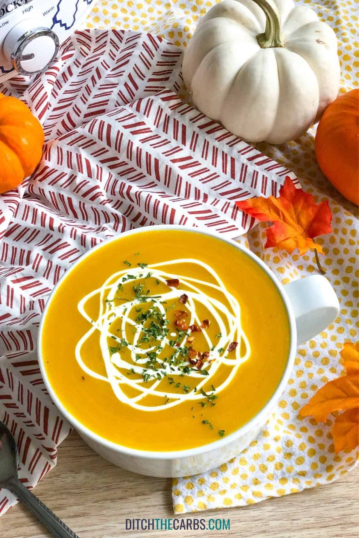 coconut cream swirled over a bowl of pumpkin and coconut soup
