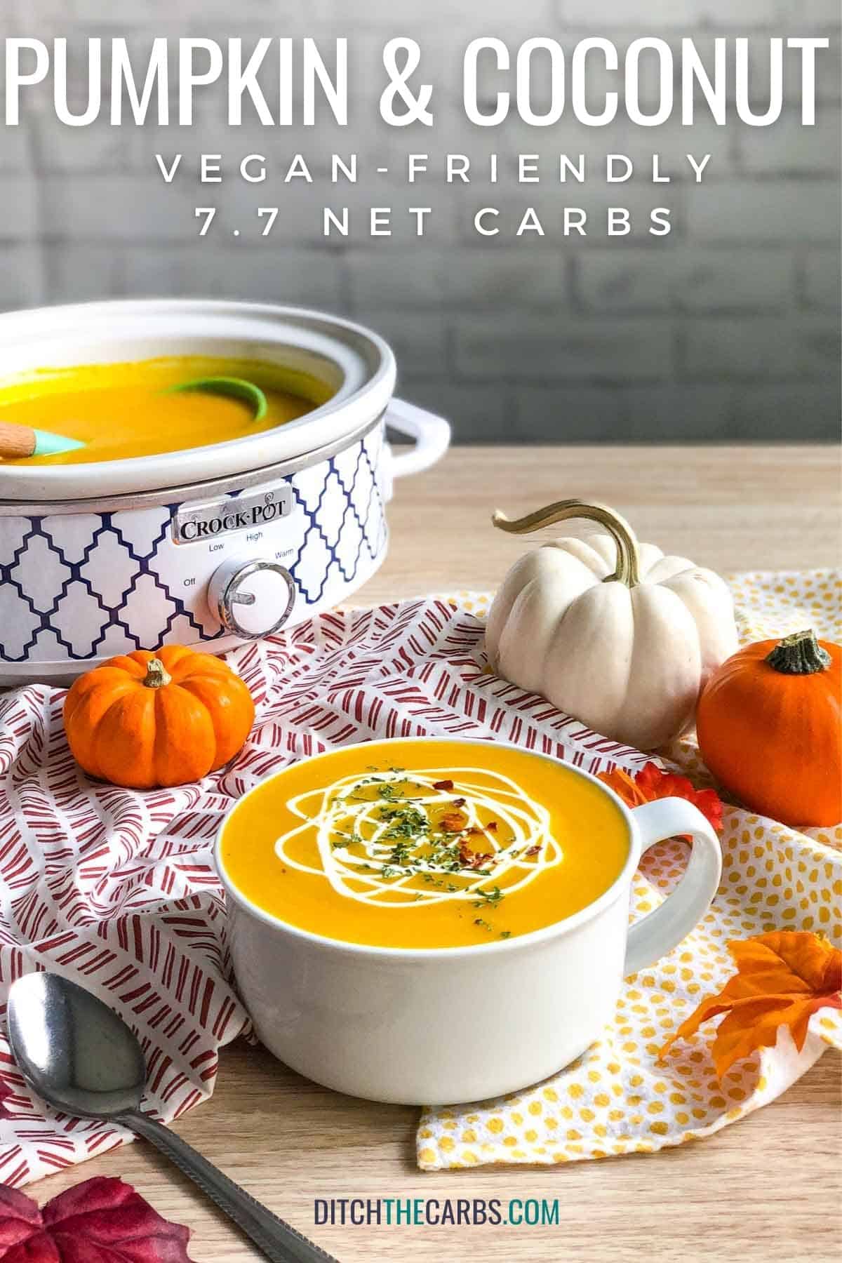 pumpkin and coconut soup with decorative pumpkins and oak leaves on a table
