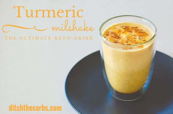 Keto turmeric milkshake sprinkled with turmeric powder in an insulated glass cup