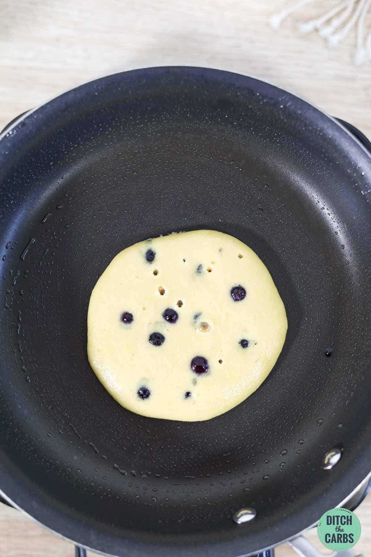 a keto pancake cooking in a frying pan