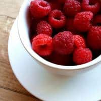 A bowl of raspberries on a plate