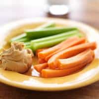 A plate of sliced vegetables with peanut butter