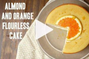 Orange cake sliced on a gray plate decorated with an orange slice