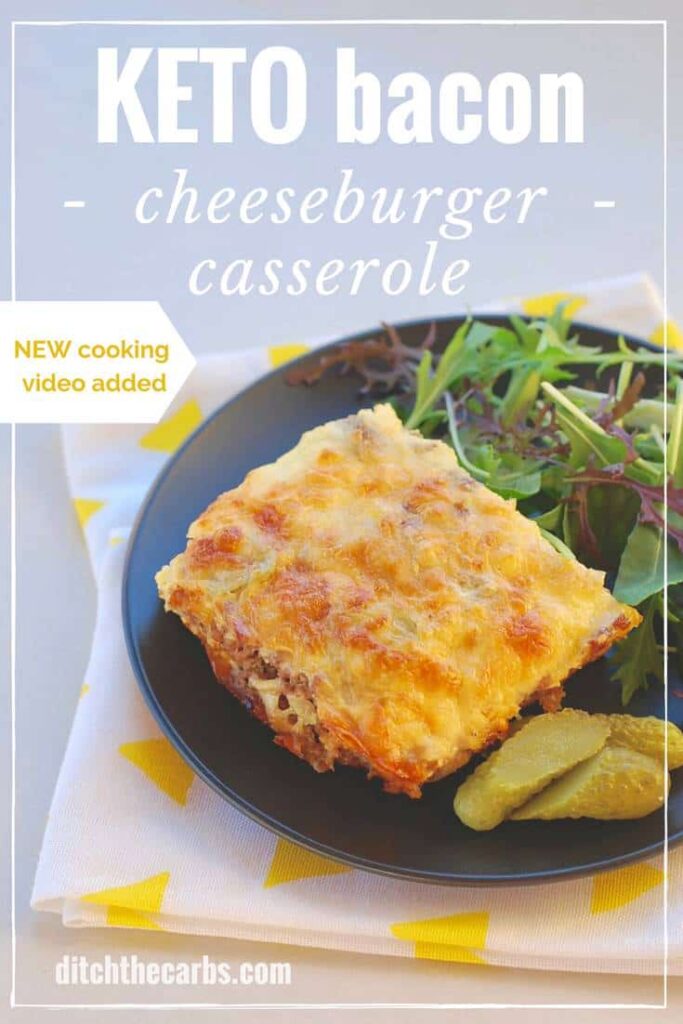 Cheeseburger casserole served on a black plate with a side salad of leafy greens
