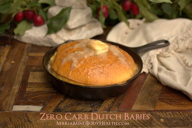 A bowl of food sitting on top of a wooden table, with Dutch baby pancake