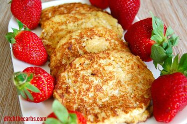 A plate of coconut pancakes with fresh strawberries