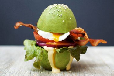 Avocado burger  sliced and egg dripping down the sides