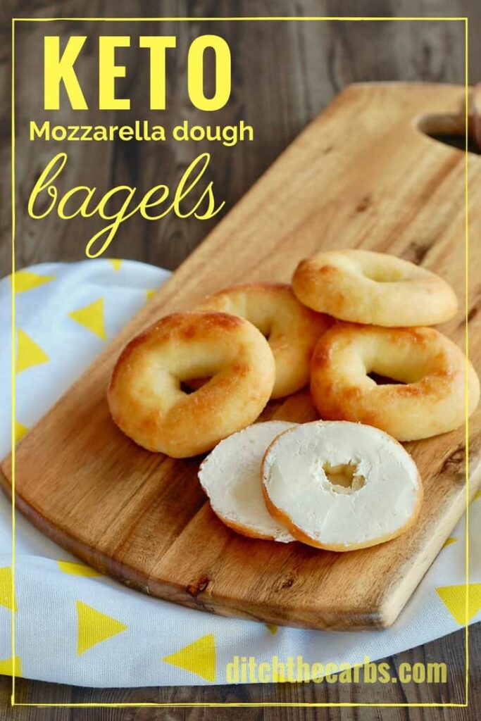 Baked mozzarella bagels sliced and sitting on a wooden chopping board