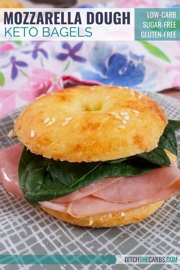 KETO copycat recipe for mozzarella dough bagels filled with ham and salad on a grey plate