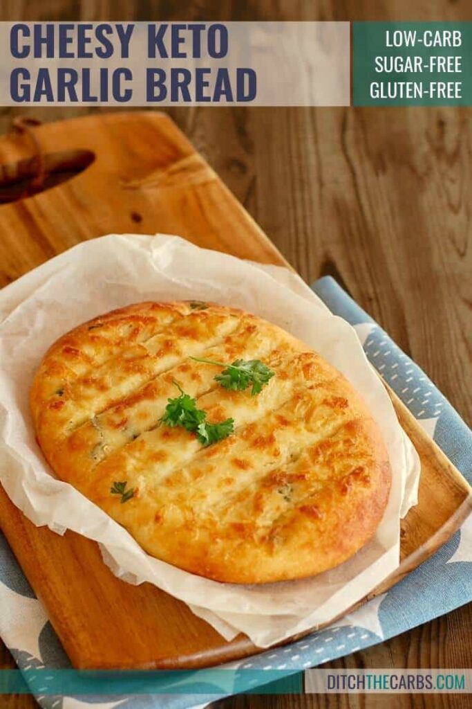 cheesy keto garlic bread sliced on a bread board