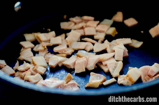 Bacon pieces frying in a pan