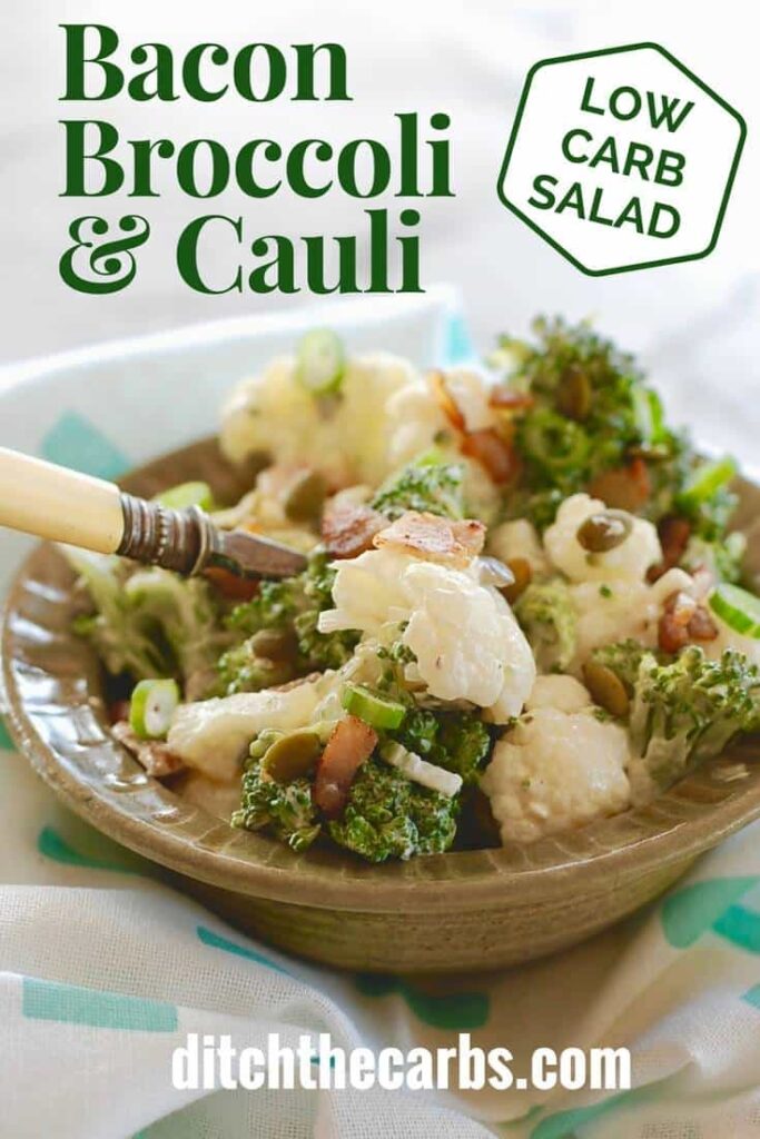 Low-carb bacon broccoli cauliflower salad served in an antique green bowl and a white ebony fork