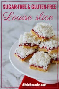 Pieces of Louise slice stacked on top of a white plate filled with sugar-free raspberry jam